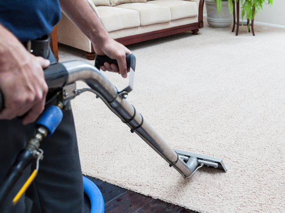 This is a photo of a man with a steam cleane r cleaning a cream carpet works carried out by Worcester Park Carpet Cleaning